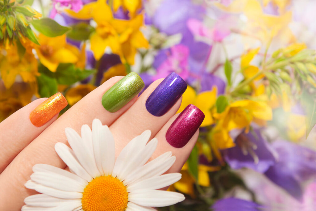 a hand with colorful nails and a flower