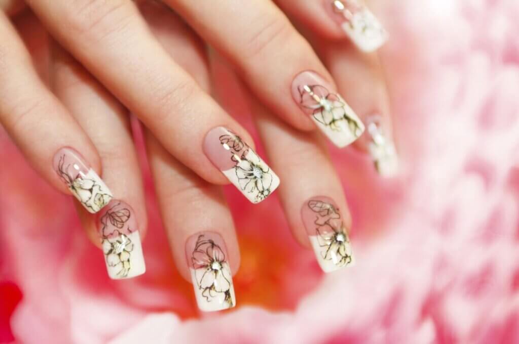 a close up of nail art showing french flowers with dual tone colors