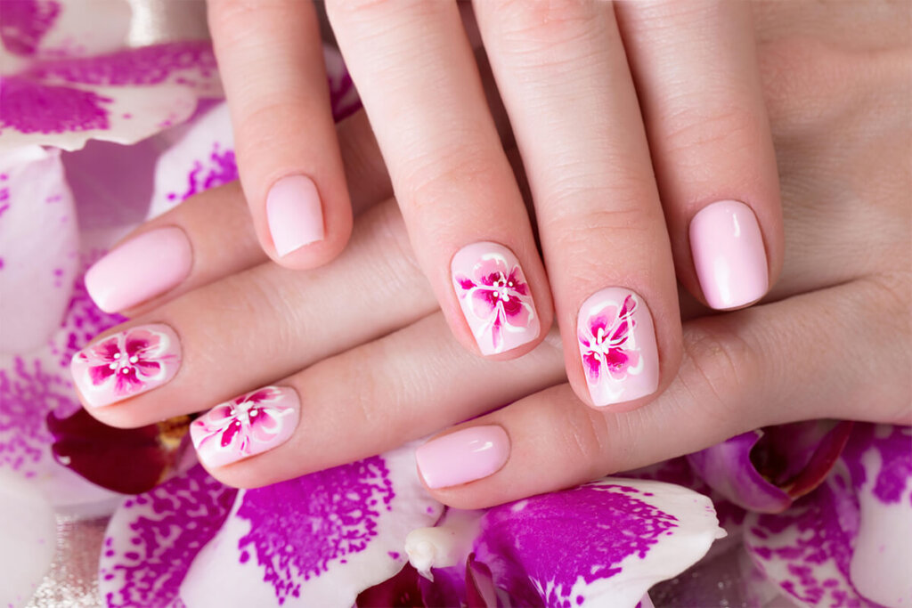 Shot beautiful manicure with flowers on female fingers. Nails design. Close up 1